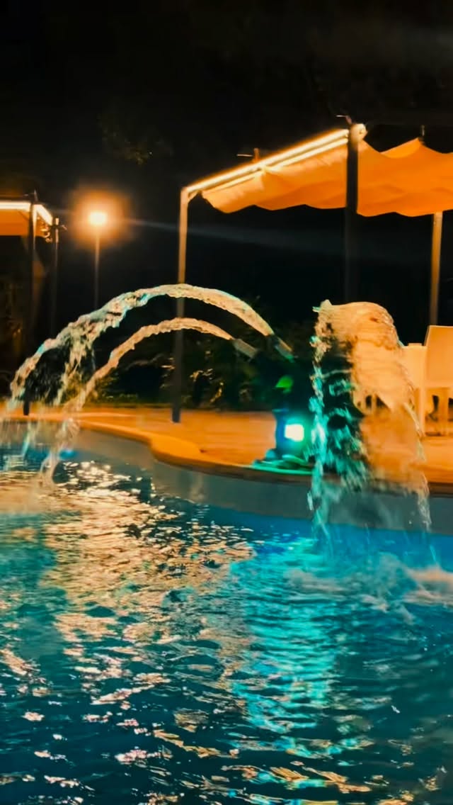 Fontana della piscina illuminata di notte